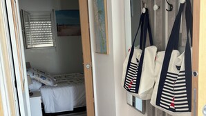 A bedroom with a bed, a dresser, a mirror, and a map on the wall. - Studio Azur et Mer tout CONFORT (Dolus-d'Oléron)