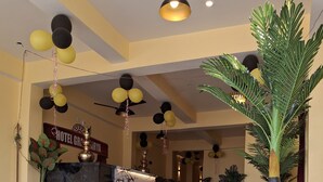 A hotel reception area with a marble counter, potted plants, and a sign reading "HOTEL GRACIA". - Hotel Grand Arya (Hilsa)