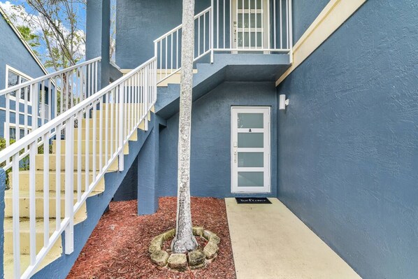 A blue building with a white staircase and a door marked 'A'. - 270A - Boca Retreat w/ Pool, Parking, Near Evert Tennis & Shops (Boca Raton)
