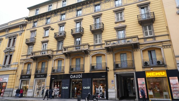 A multi-story building with storefronts including 'GAUDI' and 'HEMU'. - MyItalyHome Milano (Milan)
