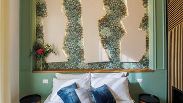 A bedroom with a large bed, two bedside tables, and a wall-mounted light fixture.