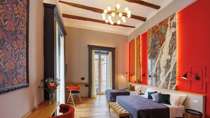 A modern bedroom with a large bed, a desk, and a chair. - The Other Duomo House (Naples)