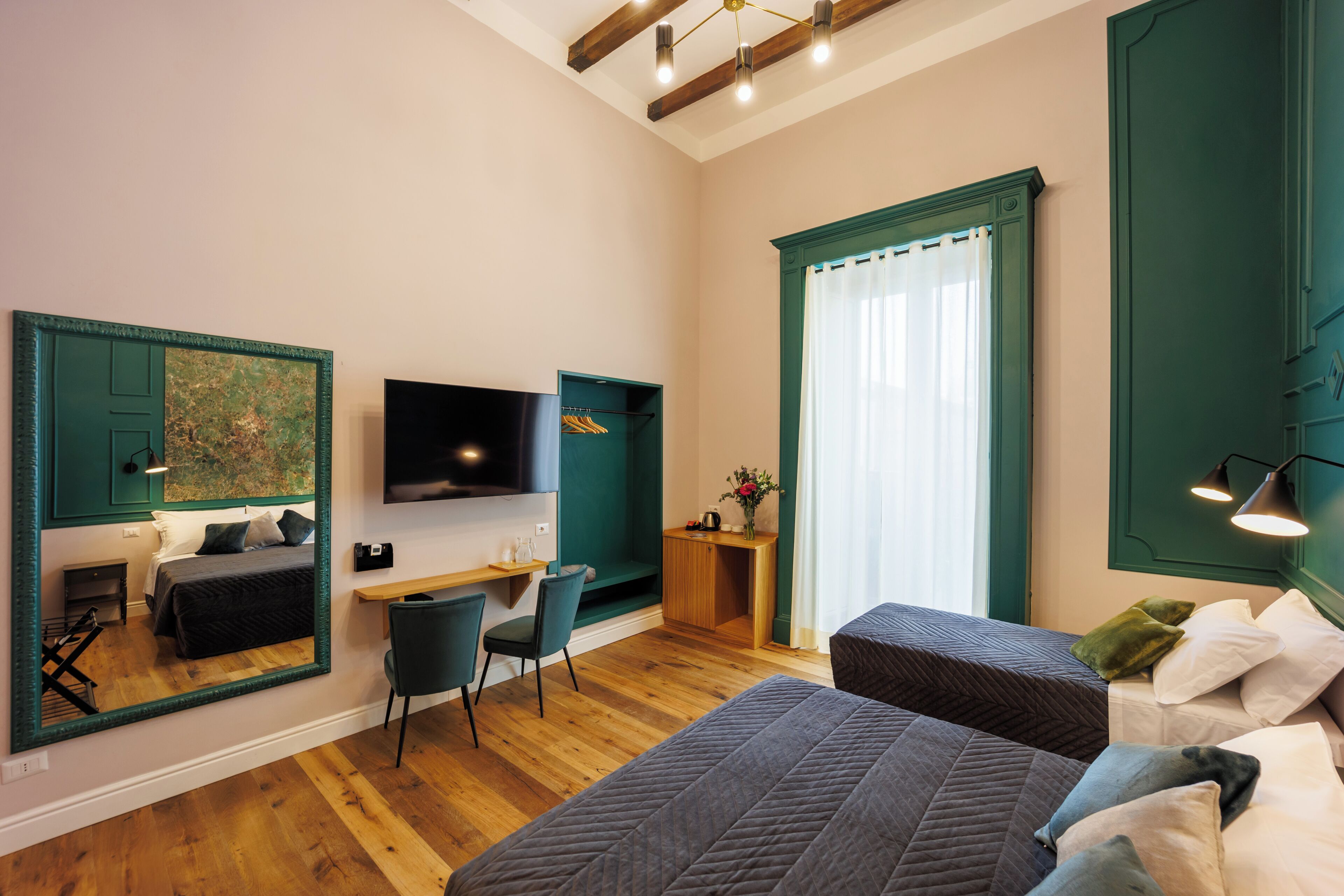 Une chambre moderne avec deux lits, un bureau, une chaise et un téléviseur.