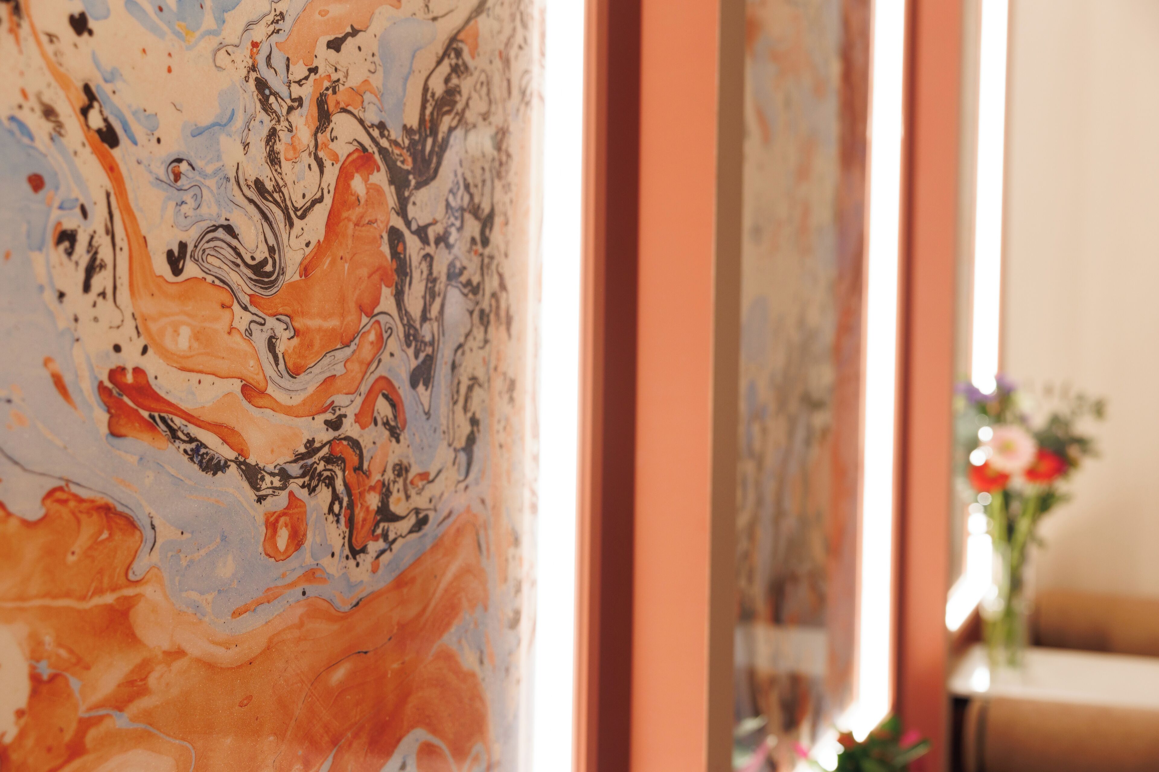 A close-up of a colorful abstract painting on a wall.