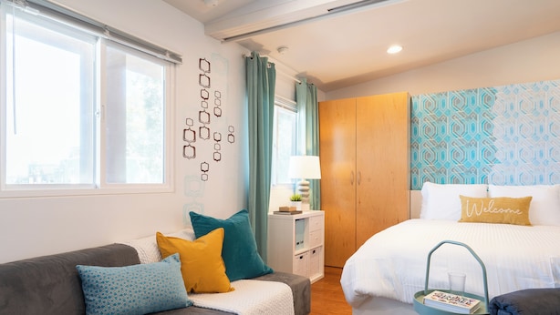 A modern bedroom with a bed, a sofa, a nightstand, and a window. - Perfect Beach Studio:  Full Kitchen, bath, steps from the ocean boardwalk, AC/Heat and parking. (San Diego)