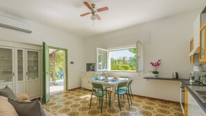 A compact living space with a dining area, kitchenette, and a view through a window.