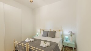 A bedroom with a bed, bedside tables, a wardrobe, and a decorative vase.