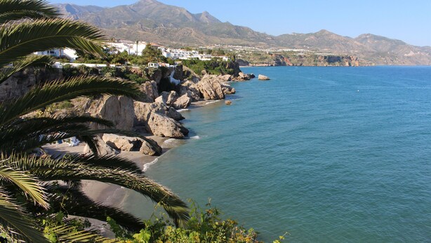 A coastal view with rocky shoreline, clear blue sea, and distant mountains. - El Escalador - Detached finca in the mountains outside Competa (Cómpeta)
