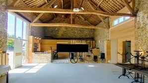 A spacious hall with a high wooden ceiling and stone walls. - La Source de nos Racines : Gîte de caractère (Beaufort)