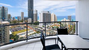 A balcony with a city view, including tall buildings and a clear sky.