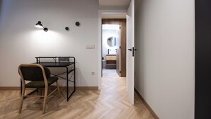 A room with a desk and chair, a door leading to a bathroom, and a herringbone-patterned floor. - Apartamento Turístico Royal (Cartagena)