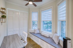 Enjoy a view of the outdoors from the comfort of this room, featuring a bench, large windows, and a dining area.