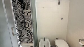 Ein Badezimmer mit Dusche, Bidet und Toilette.