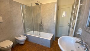 A bathroom with a glass-enclosed shower, a freestanding bathtub, a pedestal sink, and a toilet. - Art Atelier San Pietro app int loc turistica (Roma)