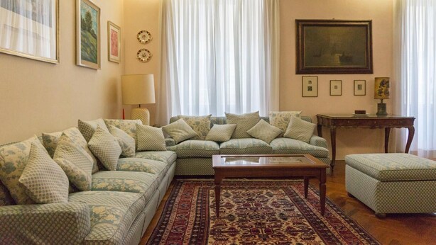 Una sala de estar con un sofá modular, una mesita y una alfombra estampada.