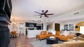 A modern living room with a sectional sofa, a coffee table, and a fireplace. - Giddy Up Getaway: Pool, Hot Tub & Family Fun! (San Antonio)