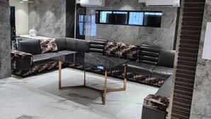A modern living room with a sectional sofa, a coffee table, and a fireplace. - HM Villas (Paud)