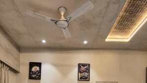 A bedroom with a large bed, a ceiling fan, marble walls, and artwork. - HM Villas (Paud)