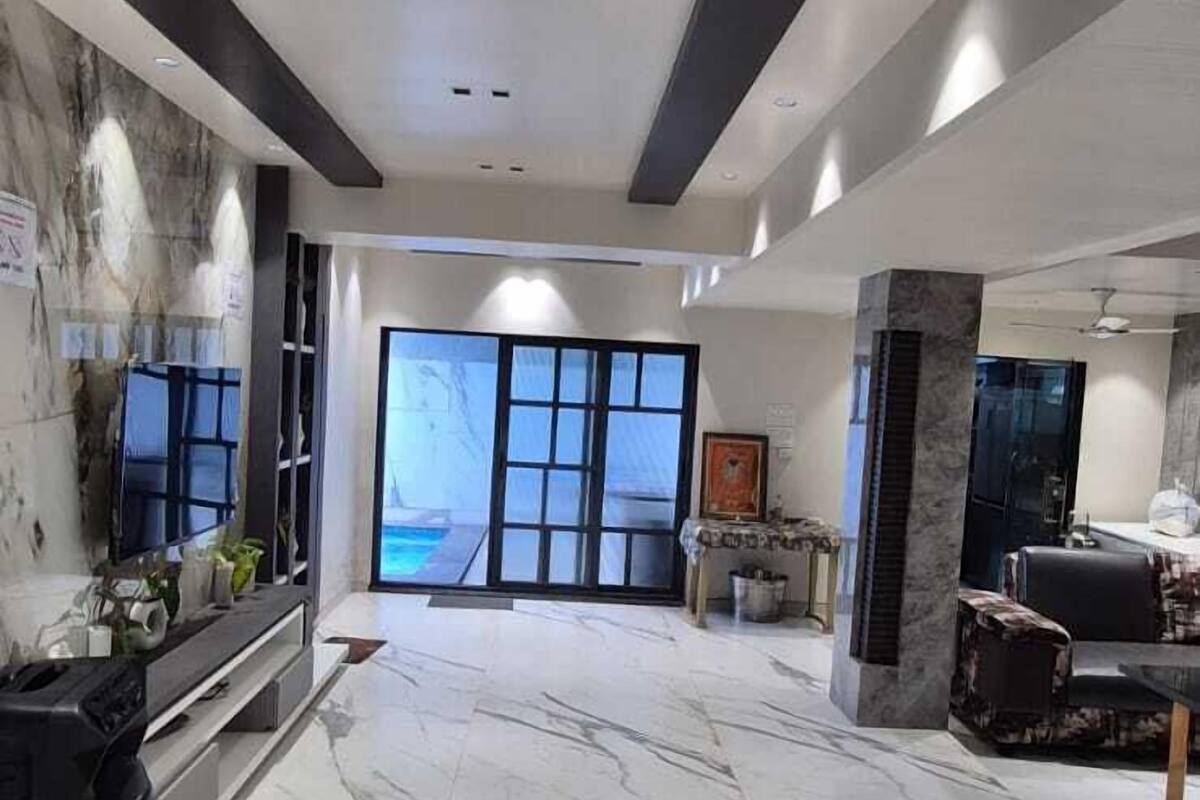Um hall amplo com piso de mármore, balcão de recepção e uma grande janela com vista.
