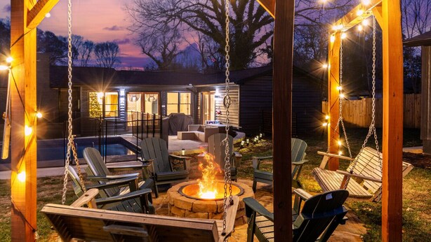 Un jardin avec une balançoire, un espace salon extérieur et un foyer.