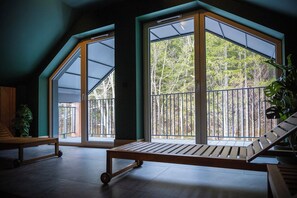 A room with large windows, a wooden bench, and a plant. - RentPlanet - Apartament Ostoja (Szklarska Poreba)