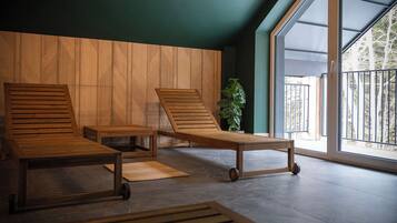 Ein modernes Zimmer mit zwei Holz-Loungesesseln, einem kleinen Tisch und einem Blumentopf.
