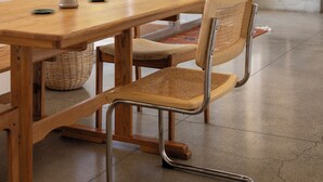 Un espace repas comprenant une table en bois, des chaises en métal et un luminaire suspendu original.
