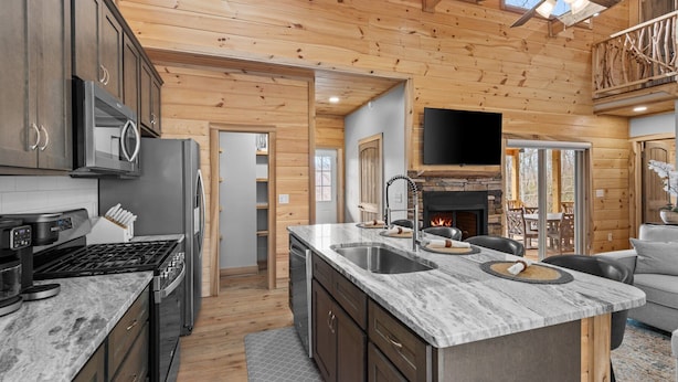A modern kitchen with granite countertops, stainless steel appliances, and a stone fireplace. - Bear Paw Getaway - Beech luxury with hot tub, fire pit (Beech Mountain)