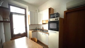 A compact kitchen with a wooden table, a sink, a stove, and cabinets. - Cozy Corner (Nova Milanese)