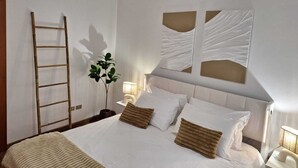 A neatly made bed with white linens, a bedside lamp, and a plant. - Cozy Corner (Nova Milanese)