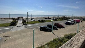 A parking lot with cars and a view of the beach and ocean. - Seafront studio with balcony and parking (Saint-Jean-de-Monts)