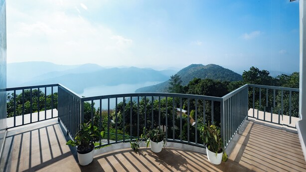 Ein Balkon mit Blick auf Berge und ein Gewässer.