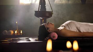 Experience a serene spa setting with a massage table, oil lamp, and tranquil ambiance.