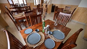 A dining table set with plates, cutlery, and a decorative vase. - The Bulevar - Alpine (Lahul)