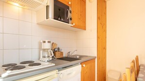 Une cuisine compacte équipée d’une cuisinière, d’un four à micro-ondes, d’un évier et d’un lave-vaisselle.