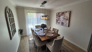 Enjoy meals in this dining area with a table for four, pendant light, and a beautiful view through the large window.