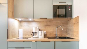 A modern kitchen with a Bosch microwave, a coffee maker, and a toaster on the counter. - Les Marmottes N°42 - 3P6 (Saint-Sorlin-d´Arves)