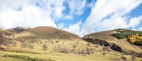 Vista panorámica de un paisaje montañoso con cielo despejado y nubes dispersas.