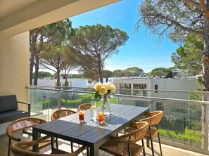 A balcony with a table, chairs, and a vase of flowers. - SanPietro Holiday Homes 296 (Gjiri Lalzit)