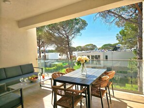 A balcony with a glass table, wicker chairs, a sofa, and a vase of flowers. - SanPietro Holiday Homes 296 (Gjiri Lalzit)