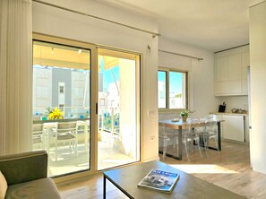 A modern apartment with a dining area, kitchen, and a balcony with outdoor furniture. - Perla Holiday Homes 253 (Gjiri Lalzit)
