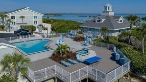 Ein Resort mit einem großen Pool, einer separaten Whirlpoolanlage und einer Liegefläche mit Liegestühlen und Sonnenschirmen.