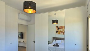 Una moderna camera d'albergo con un letto, un grande specchio e un lampadario.