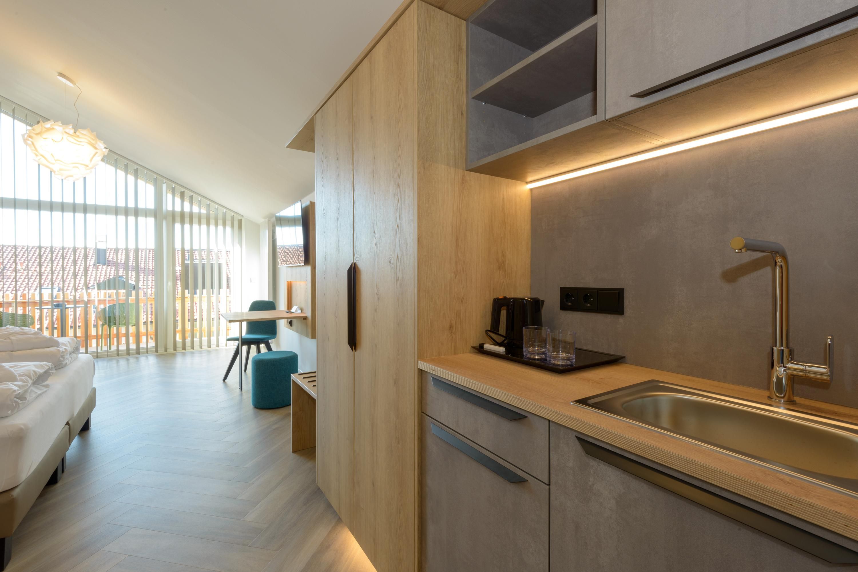 A modern kitchen with a built-in sink, a coffee maker, and a breakfast bar.