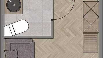 Distribución de una habitación de hotel con cama, mesitas de noche, sofá, una pequeña mesa y una silla.