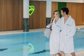 Zona de piscina con paneles de madera y una decoración de corazón luminoso.
