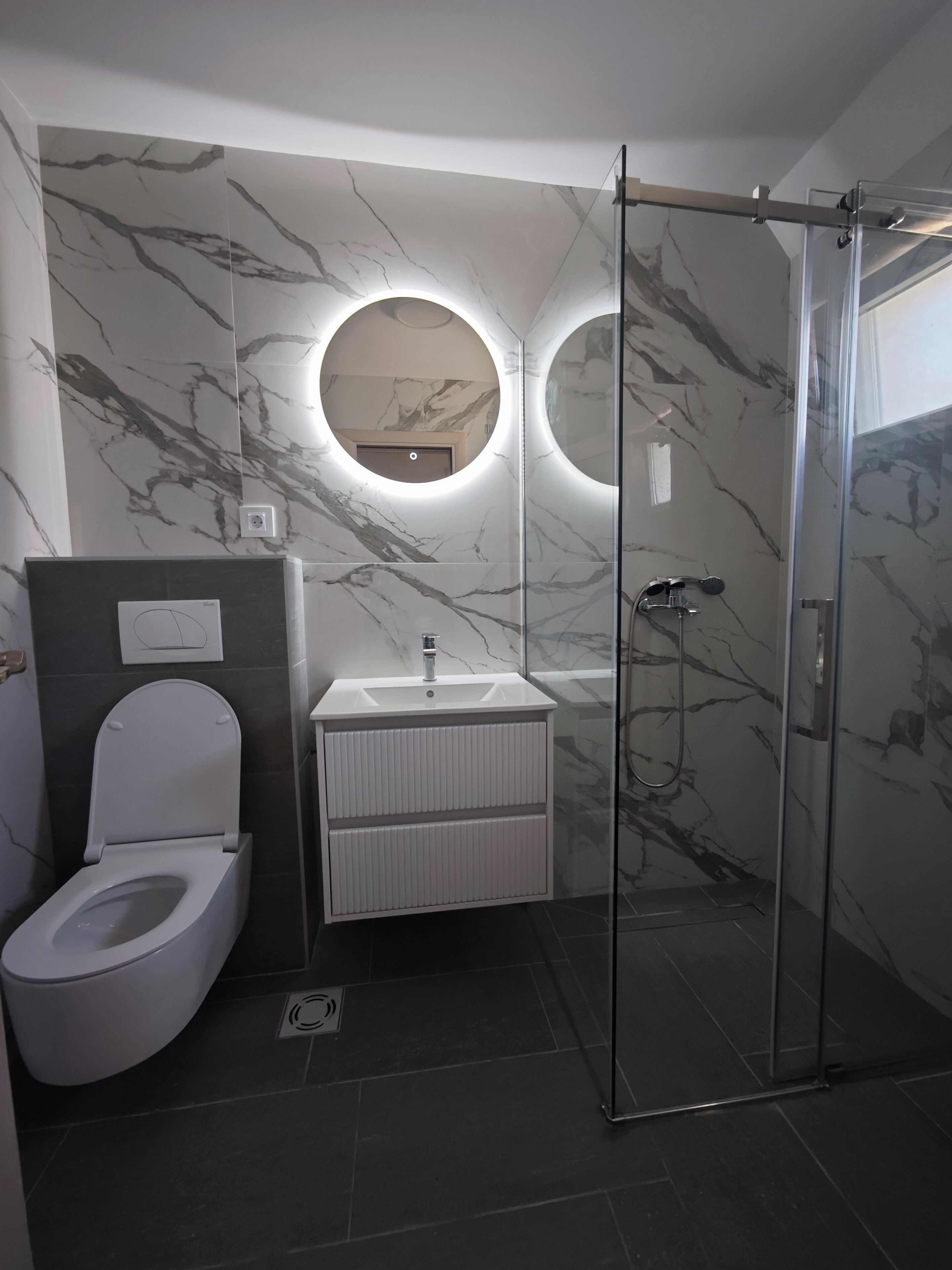 Comfort appartement | Badkamer | Een douche, een haardroger, handdoeken, zeep