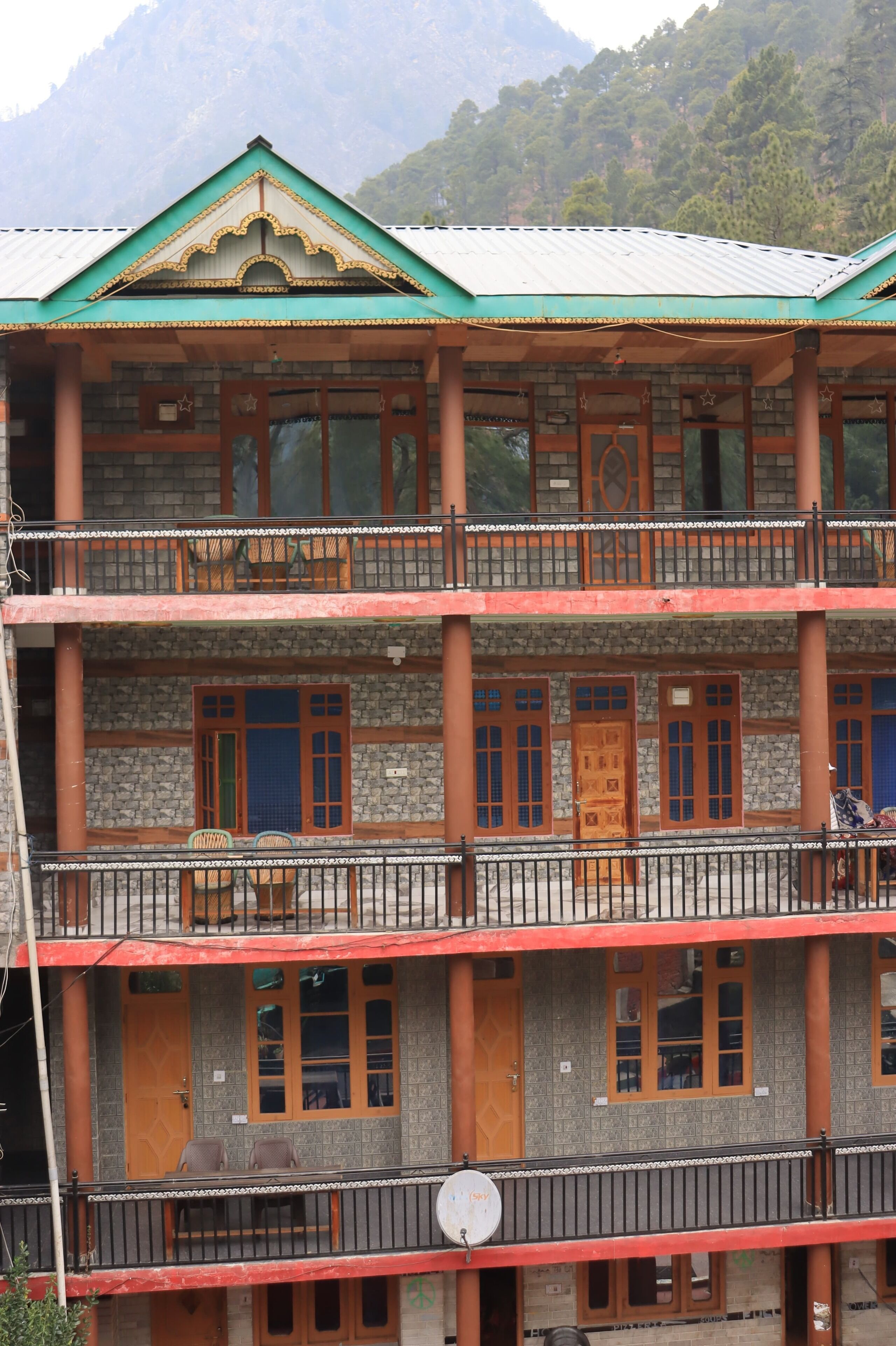 A multi-story building with balconies, windows, and doors.