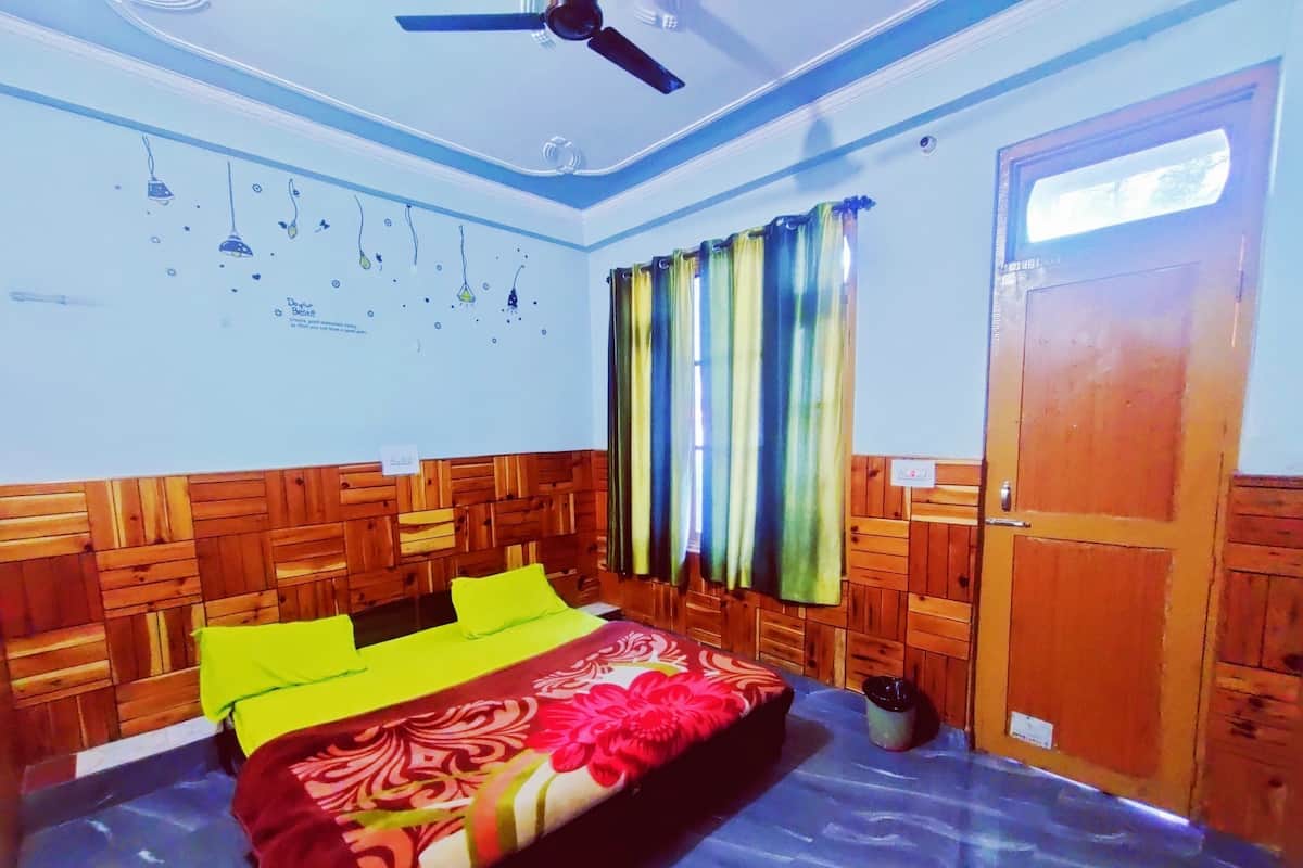 A bedroom with a wooden headboard, a bed with a floral bedspread, a ceiling fan, and a window with curtains.