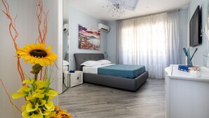 A modern bedroom with a bed, nightstand, and a desk with a chair. - Partenope – Elegant Design Apartment in the Heart of Sorrento Coast (Piano di Sorrento)